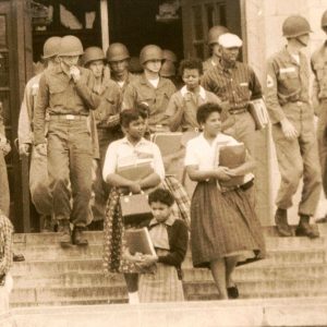 African American children on steps in front of white soldiers in uniform