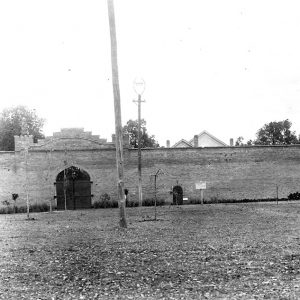 Brick wall with gate and round brick tower