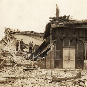 People standing amid collapsed buildings