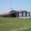 Blue metal building with white doors and red roof