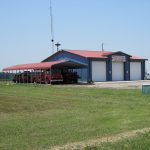 Blue metal building with white doors and red roof