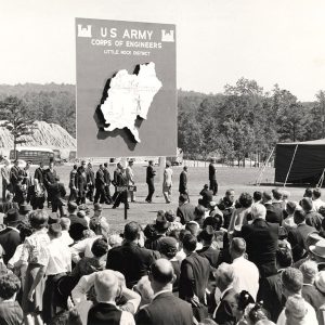 Large group of people walking past large Corps of Engineers sign