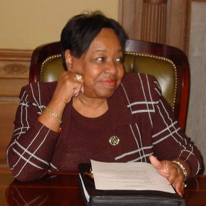 African American woman sitting at desk holding book