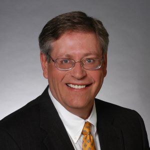 Portrait of white man in suit and tie and glasses