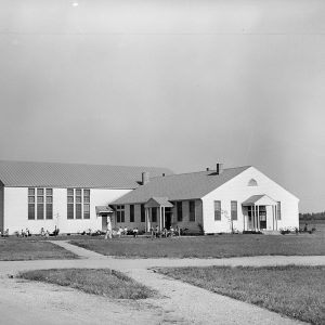 White wooden buildings with children playing out front