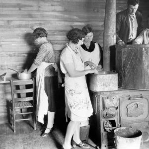 Five women and one man at work cooking