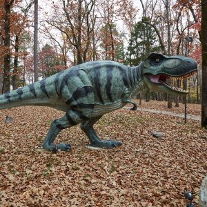 Statue of a dinosaur in wooded area