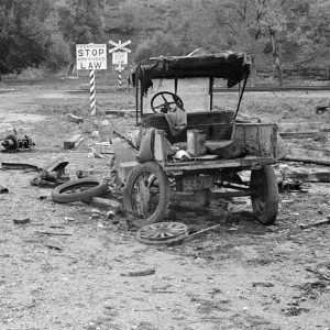 Wrecked car on road by railroad tracks