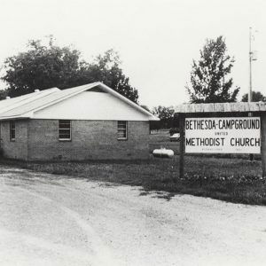 Single story brick church building next to sign saying "Bethesda Campground United Methodist Church"