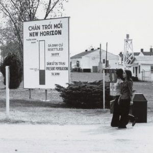 Women walking past Fort Chaffee sign