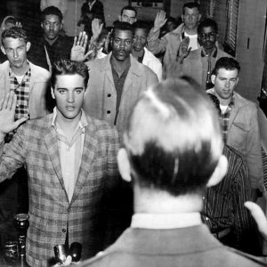 Group of white and African American men holding their right hands up