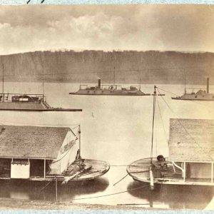 Boats floating on a river next to high bluffs