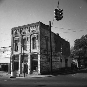 run-down looking multistory brick building with "Allen Drug Store" painted on the side