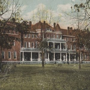 Multistory brick building with columns and trees