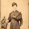 White man posing in formal military garb with hand resting on chair