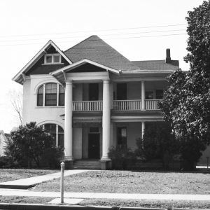 White multistory house with two pillars in front