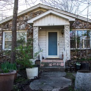 Single story rock house with covered porch