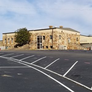 multistory rock building with staircase with a tree in the middle of it