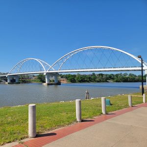 Metal bridge over river; city in background