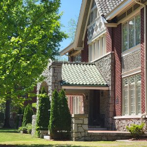 Multistory red brick house with covered front entrance and tile roof