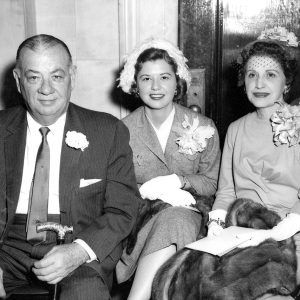 White man and two white women seated and dressed up