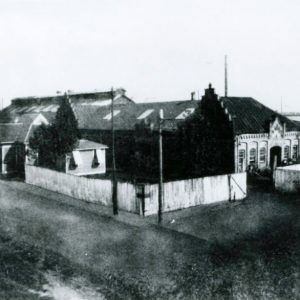 Multiple buildings behind wooden fence