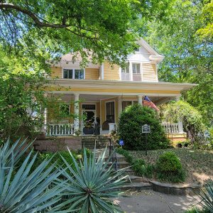 Multistory yellow house with covered porch