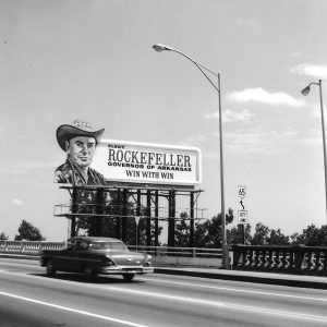 White man in cowboy hat on a billboard that says "Win with Win"