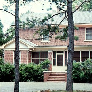 Multistory red brick building with screened porch