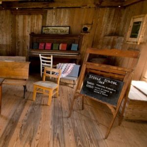 Interior of school building with desks and blackboard