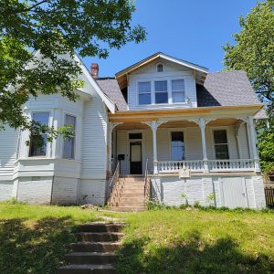 Multistory white wooden house with covered porch