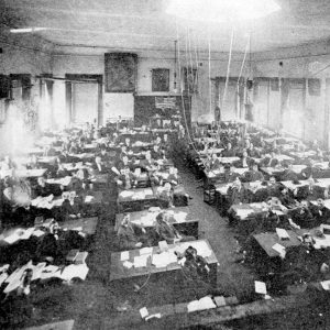 Large group of people sitting at desks in a room