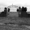 Gated entrance to a cemetery with wrought-iron arch saying "Czech National Cemetery"