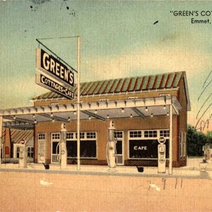 light brown building with gas pumps in front and small cottages to the side