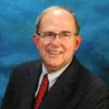 White man in suit and tie and glasses