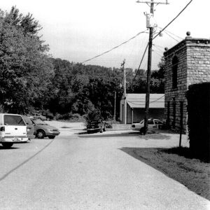 Buildings and cars on a street with trees and electrical wires