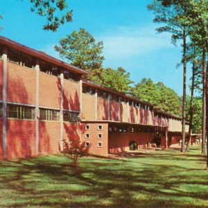 Blocky red brick buildings on wooded lot