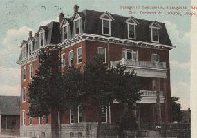 Multistory red brick building with trees in front