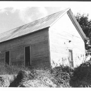 Wooden church building with entrance and three side windows