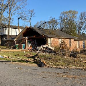 Home with side torn off and debris all around