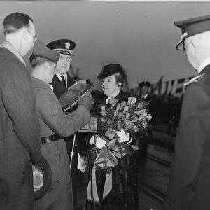 White military men and white woman holding flowers