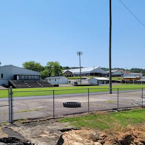 School buildings and sports track with bleachers and lights