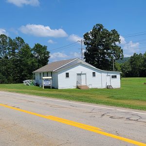 Highway with one-story white building and green grass