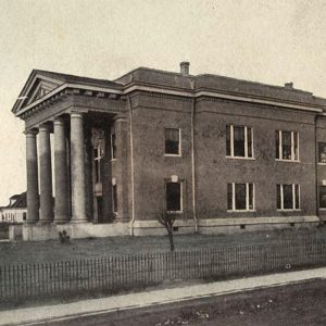 Multistory brick building with Greek columns supporting a portico