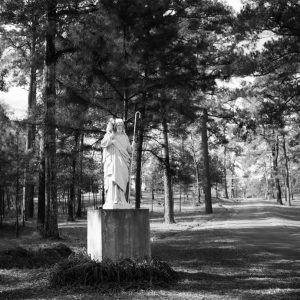 Statue of long-haired man holding lamb and staff