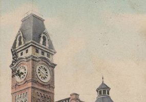 Multistory brick building with a clock tower attached