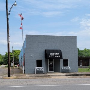 Multistory gray brick building with awning saying "Plainview City Hall"