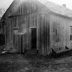 Single story dilapidated wooden building with two front doors