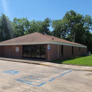 Single story red brick building with parking lot