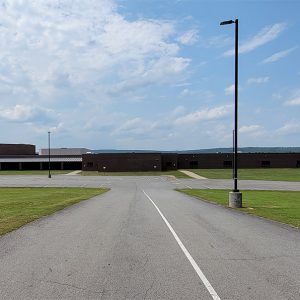 Single story red brick building adjoining single story white building